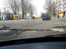 В Днепре жительница засыпала ямы на дороге