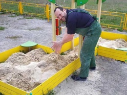 Житель Синельниково с помощниками ремонтируют детские площадки