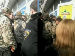 В Запорожье толпу, штурмующую магазин, успокаивали военные с автоматами