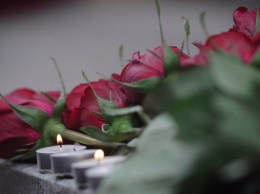 Жители несут цветы к посольству России в Киеве
