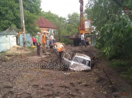 Чуть не утонули: в Харькове легковушка упала в яму, вырытую коммунальщиками