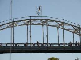 В Днепре смельчак забрался на вершину моста на Монастырский острове, чтобы водрузить флаг (ФОТО)