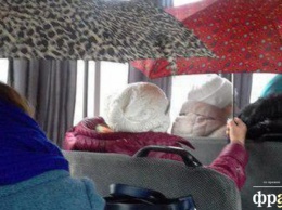 В киевской маршрутке пассажиры спасаются от дождя с помощью зонтов