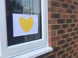 В Великобритании потерявшие родных из-за COVID семьи приклеивают на окна желтые сердца