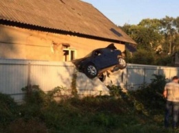 В Черновцах полицейский на BMW повис на заборе частного дома