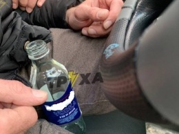 Бутылка водки в руках. В Харькове пьяный водитель уснул за рулем (видео)