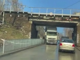 Не пролезла: на Крестьянском спуске фура застряла под мостом