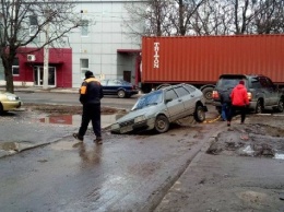 В Харькове машина застряла в огромной яме