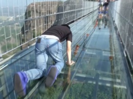В Китае турист почти час просидел на разрушенном стеклянном мосту на высоте 100 метров