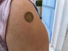 Последствия вакцинации? К руке женщины примагничиваются монеты (ВИДЕО)