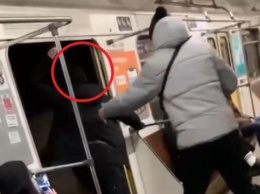 Парень на ходу высунул голову из открытой двери вагона метро в Киеве (ВИДЕО)