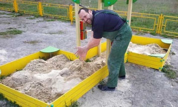 Житель Синельниково с помощниками ремонтируют детские площадки