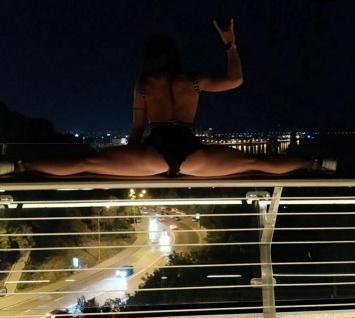 В Киеве появилась экстремальная конкурентка Волочковой, которая сделала шпагат на перилах стеклянного моста. Фото