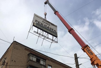 В Кривом Роге с крыши дома демонтировали аварийный билборд
