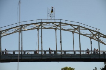 В Днепре смельчак забрался на вершину моста на Монастырский острове, чтобы водрузить флаг (ФОТО)