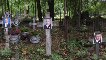 В Петербурге активисты развесили на кладбище траурные портреты Путина и Медведева