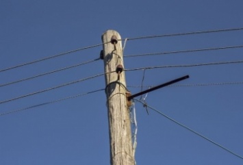 «Капитальный ремонт»: в Запорожье падающую электроопору примотали проволокой к забору (ВИДЕО)