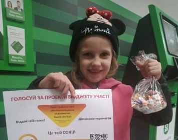 В Днепре 6-летняя девочка раздает конфеты взрослым на улице