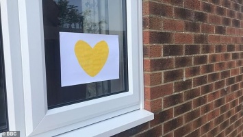 В Великобритании потерявшие родных из-за COVID семьи приклеивают на окна желтые сердца