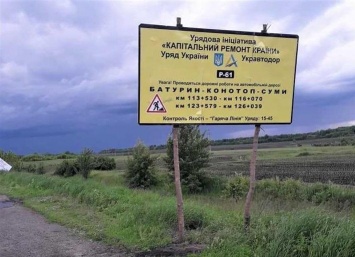 В Сумской области стенды о ремонте дороги повесили на стволы спиленных деревьев (фото)