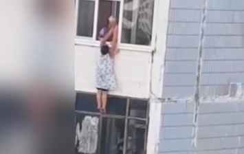 В Запорожье женщина висела на окне девятого этажа