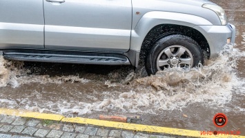 Сильный ливень в Днепре затопил дороги: заглохли машины и провалился асфальт