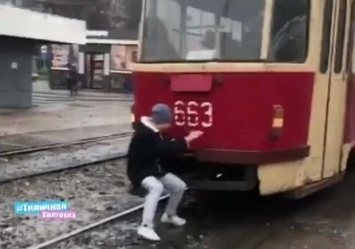 Видеофакт: на Салтовке зацепер упал на рельсы, сорвавшись с трамвая