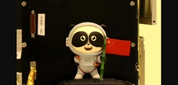 Китай отправил в космос большую панду, которая держит в руках флаг страны. Фото