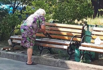 Чтобы не мешали спать: в Киеве бабушка распилила скамейку во дворе