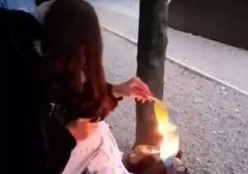 Под смех друзей: в Каменском девушка сожгла украинский флаг